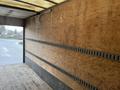 A 2012 Mitsubishi Fuso FE truck with an empty wooden cargo space featuring smooth walls and a wooden floor