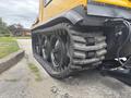 Close-up of a 2004 Bombardier SW48 showcasing its rugged tracked undercarriage with three large rubber tracks designed for enhanced traction on various terrains