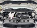The image shows the engine compartment of a 2020 Chevrolet Express with various components including the engine block battery and cooling system parts