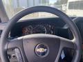 The steering wheel of a 2011 Chevrolet Express with dashboard gauges and warning lights visible behind it