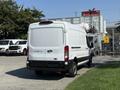 A white 2022 Ford Transit van is parked with its rear facing the viewer showcasing its design and cargo space