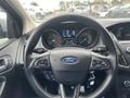 Steering wheel of a 2018 Ford Focus with controls and logo visible dashboard displays speed and fuel levels