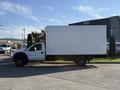 A white 2010 Ford F-450 box truck parked sideways with a large blank cargo box in the back