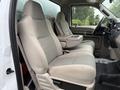 Two tan fabric front seats of a 2008 Ford F-450 SD with a center console in between them
