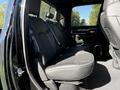 The interior of a 2021 RAM 3500 showing the back seat with black leather upholstery and a spacious design