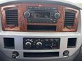 Dashboard of a 2006 Dodge Ram 2500 featuring a radio, controls for climate and power, and decorative wood trim