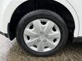 Close-up of a silver alloy wheel with a six-spoke design and a black tire featuring tread patterns on a 2012 Nissan Versa