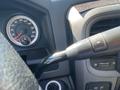 Close-up of the dashboard and steering column of a 2015 RAM 2500 featuring a speedometer and control buttons on the steering wheel