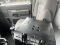 A black RAM tough tray mounted on a seat in a 2009 Ford Econoline van