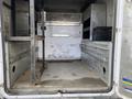 Interior view of a 2015 Ford F-550 truck showing an empty cargo area with metal storage compartments and a diamond plate floor