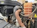 Close-up view of the engine components of a 2011 International WorkStar including pipes wires and a coolant reservoir