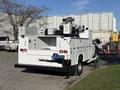 A 2009 Ford F-550 utility truck with a white body and multiple compartments in the rear for tools and equipment
