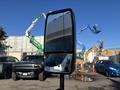 A 2017 Ford Transit-350 side mirror reflecting the vehicle's body and nearby objects in the parking lot