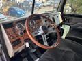 Interior view of a 2008 Peterbilt 340 showing a wooden steering wheel and various gauges and controls on the dashboard