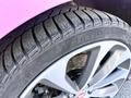 Close-up of a tire and alloy wheel of a 2020 Jaguar XE featuring a Pirelli tire with intricate tread design and shiny silver spokes