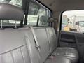 The interior of a 2006 Dodge Ram 2500 featuring gray leather seats in the back with a seatbelt attached