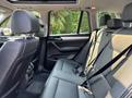 Interior view of a 2013 BMW X3 showcasing black leather back seats with seat belts and a panoramic sunroof above