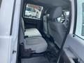 Interior view of a 2015 Ford F-550 showcasing the rear passenger seating area with two rows of seats in light gray upholstery