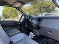 Interior view of a 2011 Ford F-550 showing gray seats a dashboard with control panels and audio system