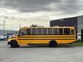 A 2022 Freightliner B2 yellow school bus with black trim facing left with multiple windows visible along its side