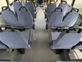 Interior view of a 2017 Chevrolet Express showing rows of blue upholstered seats with safety straps and a flat floor design