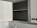 A metal cabinet door is open revealing empty shelves inside