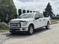 A white 2017 Ford F-150 pickup truck with chrome accents parked on a paved surface featuring four doors and all-terrain tires