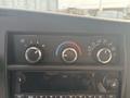 Car climate control panel with three adjustable dials for fan speed temperature and air distribution settings along with a digital media display below