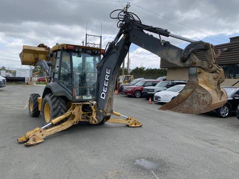 A 2012 John Deere 310SJ backhoe loader with a yellow and black color scheme featuring a front bucket and a rear digging arm