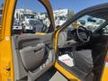 A yellow 2013 Chevrolet Silverado 1500 with an open driver's door and interior showing the dashboard and seating area