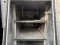 Interior of a 2015 Ford F-350 storage compartment with two metal shelves and a flat bottom
