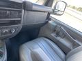 Interior view of a 2023 GMC Savana showing the driver's seat dashboard and door controls