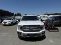 A white 2019 Ford F-150 pickup truck facing forward with a chrome grille and headlights visible