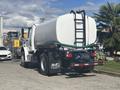 A 2022 Freightliner M2 106 truck with a large water tank mounted on the back featuring a hose reel and ladder attached to the tank