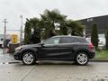 A black 2016 Mercedes-Benz GLA-250 parked on a wet surface showcasing its sleek design and modern features