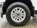 Close-up of a silver alloy wheel on a 2019 Ford F-350 SD featuring aggressive off-road tires with visible tread patterns and a shiny center cap