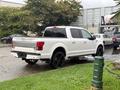 A white 2018 Ford F-150 parked with black rims and a double cab design
