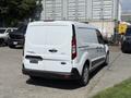 A white 2021 Ford Transit Connect van viewed from the rear with sliding side doors and a plain rear door without any visible branding or license plate