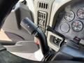 A close-up view of the turn signal lever on the steering column of a 2011 International 7500 featuring various indicator lights and a gear shift selector