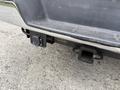 A rear view of a 2004 Chevrolet Express showing the hitch receiver and electrical connection mounted below the bumper