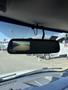 A rearview mirror showing a video feed of the road behind while inside a 2016 GMC Savana