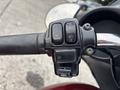 Close-up of the handlebar controls of a 2009 Harley-Davidson Road King featuring buttons for horn lights and audio functions