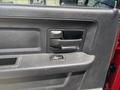 Close-up of the interior door handle and control panel of a 2013 RAM 2500 featuring a textured black surface and a window control button