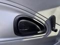 A close-up of the interior door panel of a 2006 International 4300 showing a black handle and a window crank with a textured gray background