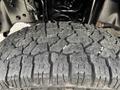 Close-up of a rugged tire tread on a 2013 Ford F-250 SD showcasing deep grooves and thick rubber designed for off-road traction