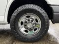 Close-up of a chrome wheel from a 2021 Chevrolet Express featuring a distinctive bowtie logo and rugged tire tread designed for durability and traction