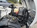 A 2018 Ford F-750 with its hood open showcasing the engine and various components including the battery coolant reservoir and wiring harnesses