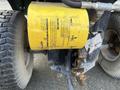A yellow oil filter mounted on the side of a 2021 John Deere L Series S tractor with visible text and a metal attachment point
