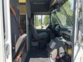 Interior view of a 2012 Ford Econoline showing the driver's seat dashboard and controls with a passenger seat beside it