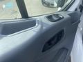 Close-up of the door handle and control panel of a 2017 Ford Transit with gray interior features and a textured surface